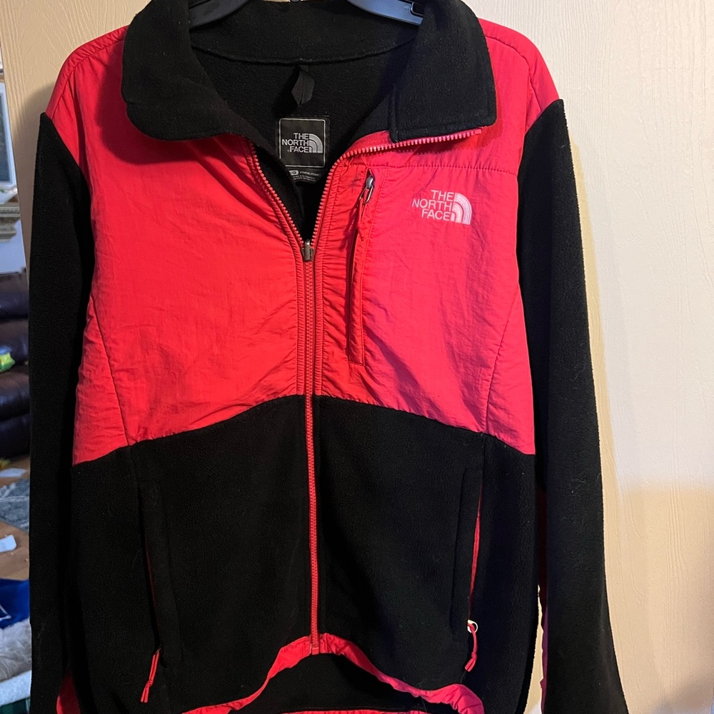 Women’s north face. Kind of a orangey red color